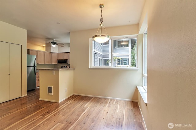 3924 243rd Pl SE Unit G204, Bothell, WA 98201 - kitchen featuring freestanding refrigerator, stainless steel microwave, a peninsula, light wood-style flooring, and heating unit