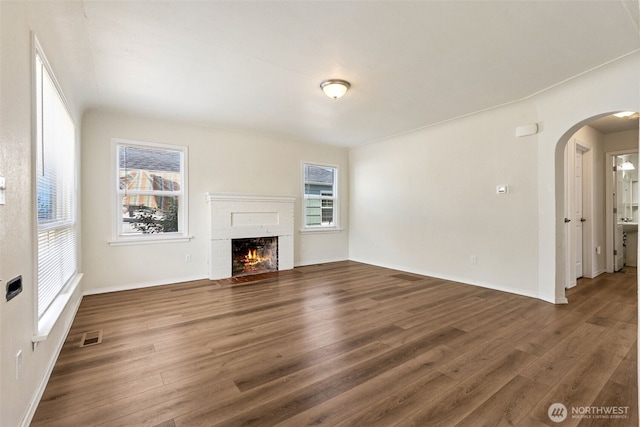 3154 Pear St SE, Olympia, WA 98501 - unfurnished living room with wood finished floors, arched walkways, and a fireplace