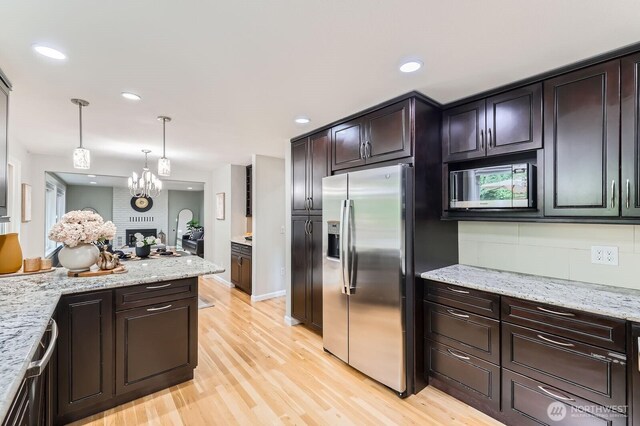 14111 NE 63rd Ct, Redmond, WA 98052 - kitchen featuring stainless steel appliances, light wood-style floors, pendant lighting, a chandelier, and recessed lighting