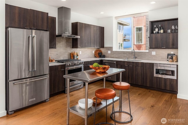 1918 5th Ave N Unit B, Seattle, WA 98109 - kitchen featuring high quality appliances, wall chimney range hood, dark brown cabinetry, and recessed lighting