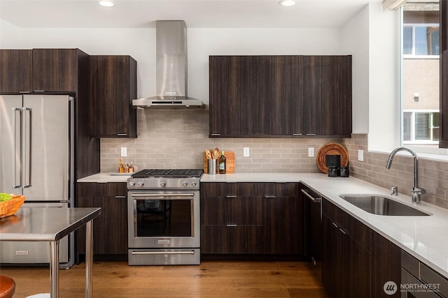 1918 5th Ave N Unit B, Seattle, WA 98109 - kitchen with stainless steel appliances, wall chimney exhaust hood, modern cabinets, dark brown cabinetry, and recessed lighting