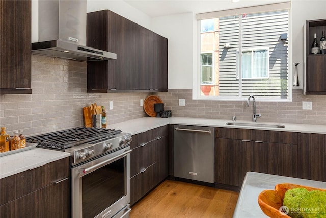 1918 5th Ave N Unit B, Seattle, WA 98109 - kitchen featuring wall chimney range hood, appliances with stainless steel finishes, light countertops, and modern cabinets