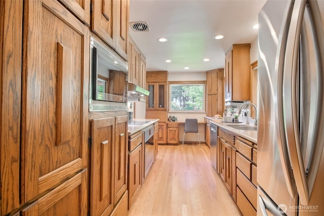 2404 SW 170th St, Burien, WA 98166 - kitchen with appliances with stainless steel finishes, light wood-style floors, light countertops, recessed lighting, and under cabinet range hood