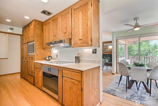 2404 SW 170th St, Burien, WA 98166 - kitchen featuring wall oven, under cabinet range hood, light wood-style flooring, light countertops, and electric cooktop