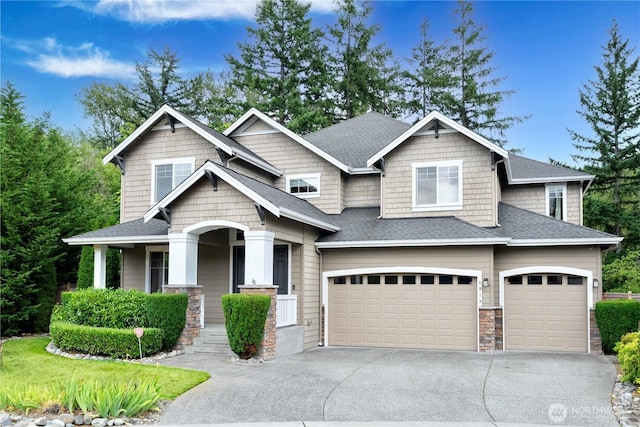 8019 149th Pl SE, Newcastle, WA 98059 - craftsman house featuring an attached garage, concrete driveway, stone siding, covered porch, and roof with shingles