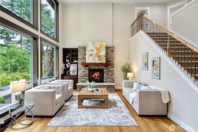 8019 149th Pl SE, Newcastle, WA 98059 - living area with a towering ceiling, healthy amount of natural light, a fireplace, wood finished floors, and stairs