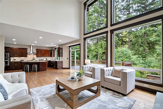 8019 149th Pl SE, Newcastle, WA 98059 - living area with healthy amount of natural light, light wood-type flooring, recessed lighting, and a towering ceiling