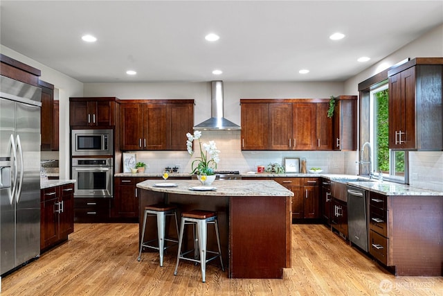 8019 149th Pl SE, Newcastle, WA 98059 - kitchen featuring built in appliances, wall chimney exhaust hood, a kitchen island, light wood-style floors, and decorative backsplash