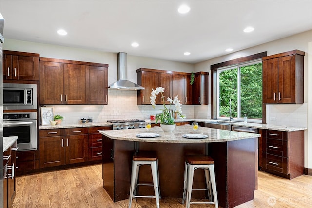 8019 149th Pl SE, Newcastle, WA 98059 - kitchen featuring wall chimney range hood, stainless steel appliances, a kitchen island, a breakfast bar, and decorative backsplash