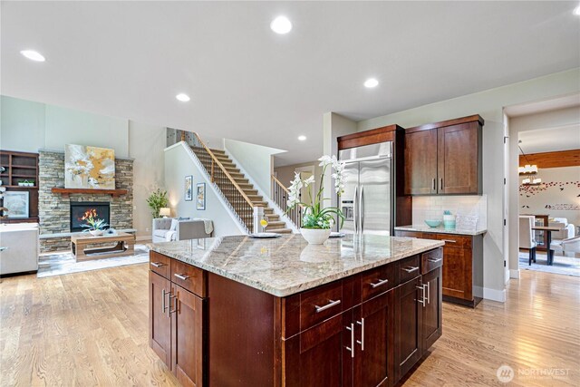 8019 149th Pl SE, Newcastle, WA 98059 - kitchen with built in refrigerator, light wood-style flooring, tasteful backsplash, light stone countertops, and a kitchen island
