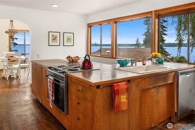 10634 SW Cowan Rd, Vashon, WA 98070 - kitchen with appliances with stainless steel finishes, dark wood-style flooring, brown cabinetry, a water view, and recessed lighting