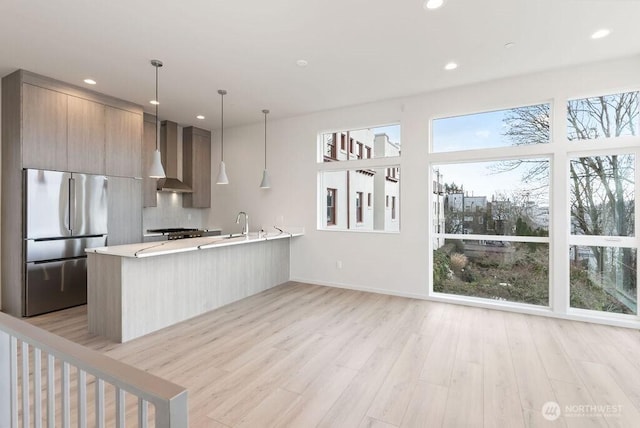 2921 Franklin Ave E Unit B, Seattle, WA 98102 - kitchen featuring stainless steel refrigerator, modern cabinets, light countertops, light wood-style flooring, and a peninsula