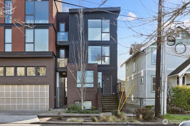 4422 Woodlawn Ave N Unit 213, Seattle, WA 98103 - view of front of home with brick siding, concrete driveway, and an attached garage