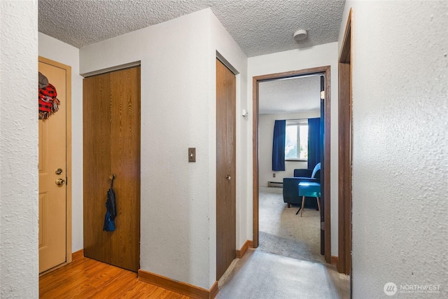 7310 N Skyview Ln Unit J-301, Tacoma, WA 98406 - corridor with a textured ceiling, a baseboard heating unit, and a textured wall