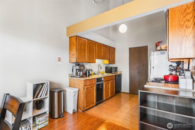 7310 N Skyview Ln Unit J-301, Tacoma, WA 98406 - kitchen with light countertops, light wood finished floors, black dishwasher, freestanding refrigerator, and brown cabinets