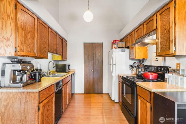 7310 N Skyview Ln Unit J-301, Tacoma, WA 98406 - kitchen featuring black appliances, under cabinet range hood, light countertops, light wood-style floors, and brown cabinetry