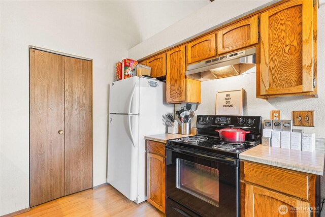 7310 N Skyview Ln Unit J-301, Tacoma, WA 98406 - kitchen with electric range, under cabinet range hood, freestanding refrigerator, light countertops, and brown cabinets