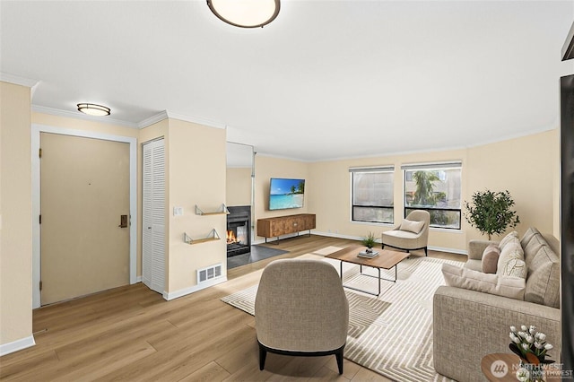 500 W Roy St Unit 102, Seattle, WA 98119 - living room featuring light wood-style flooring, crown molding, and a glass covered fireplace