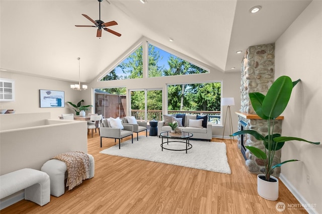 21945 Promontory Ct SE, Yelm, WA 98597 - living area featuring a ceiling fan, high vaulted ceiling, wood finished floors, and a chandelier