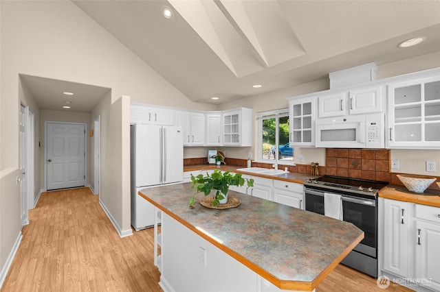 21945 Promontory Ct SE, Yelm, WA 98597 - kitchen with white appliances, white cabinetry, light wood-style floors, a skylight, and recessed lighting
