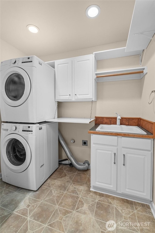 21945 Promontory Ct SE, Yelm, WA 98597 - laundry area featuring stacked washer / dryer, cabinet space, and recessed lighting