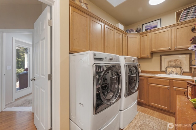 461 Klahhane Rd, Sequim, WA 98382 - laundry room featuring washing machine and clothes dryer, light wood-style floors, and cabinet space