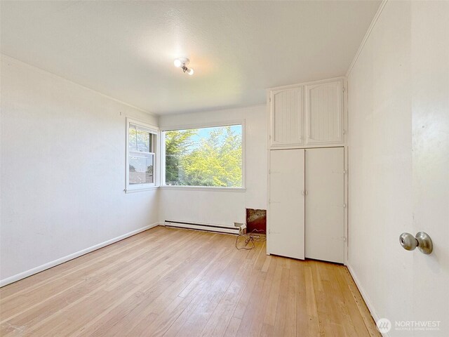 2310 S Laurel St, Port Angeles, WA 98362 - unfurnished bedroom with a baseboard heating unit and light wood-type flooring