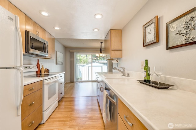 2913 27th St SE, Auburn, WA 98092 - kitchen with stainless steel appliances, light wood-style flooring, light countertops, recessed lighting, and a chandelier