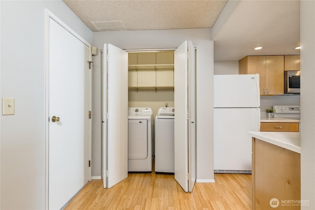 2913 27th St SE, Auburn, WA 98092 - laundry area with washer and clothes dryer, light wood-style flooring, and recessed lighting