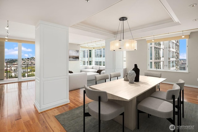 2600 2nd Ave Unit 2501, Seattle, WA 98121 - dining area with light wood-type flooring, a raised ceiling, and ornamental molding