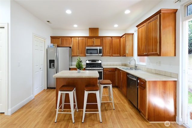 28710 S 34th Ave Unit B5, Auburn, WA 98001 - kitchen featuring stainless steel appliances, brown cabinetry, light wood-style floors, a kitchen island, and recessed lighting