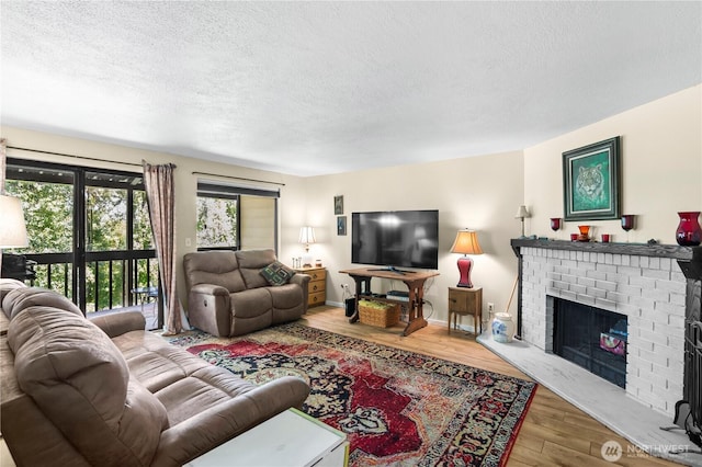 1211 N 8th St Unit 4, Mount Vernon, WA 98273 - living area with a textured ceiling, wood finished floors, and a brick fireplace