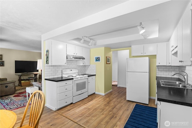 1211 N 8th St Unit 4, Mount Vernon, WA 98273 - kitchen featuring white appliances, dark countertops, a raised ceiling, white cabinetry, and tasteful backsplash