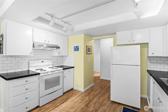 1211 N 8th St Unit 4, Mount Vernon, WA 98273 - kitchen with white appliances, under cabinet range hood, rail lighting, dark countertops, and light wood-style floors