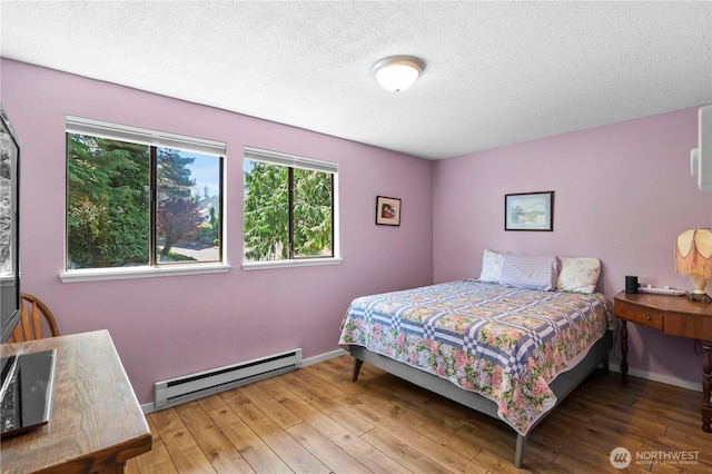 1211 N 8th St Unit 4, Mount Vernon, WA 98273 - bedroom featuring a baseboard radiator, wood-type flooring, and a textured ceiling