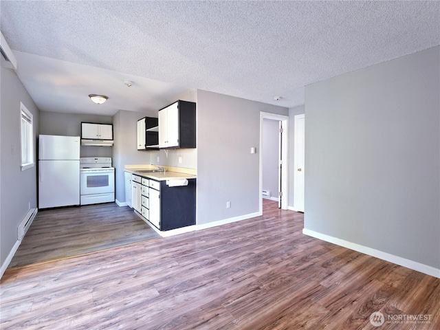2716 S 256th Pl, Kent, WA 98032 - kitchen with white appliances, a baseboard radiator, wood finished floors, under cabinet range hood, and a textured ceiling