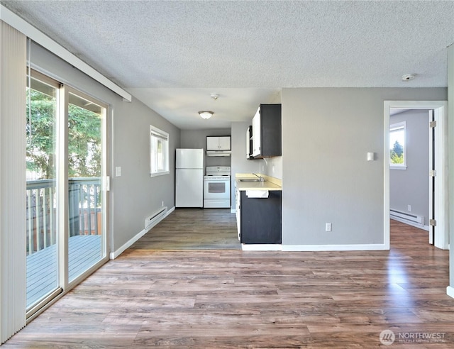 2716 S 256th Pl, Kent, WA 98032 - kitchen with white appliances, baseboard heating, a textured ceiling, light countertops, and wood finished floors