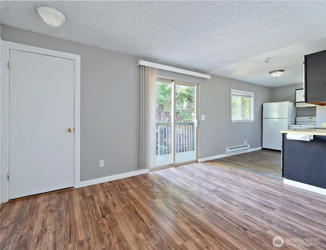 2716 S 256th Pl, Kent, WA 98032 - unfurnished living room featuring baseboard heating, wood finished floors, and a textured ceiling