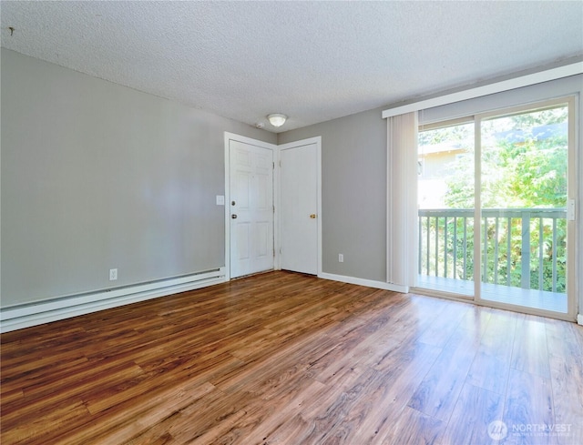 2716 S 256th Pl, Kent, WA 98032 - unfurnished room featuring a baseboard heating unit, a textured ceiling, wood finished floors, and healthy amount of natural light