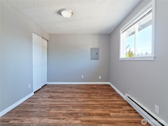 2716 S 256th Pl, Kent, WA 98032 - spare room featuring a baseboard heating unit, electric panel, a textured ceiling, and wood finished floors