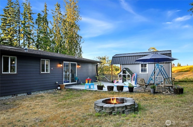 29 Sherburne Rd, Sequim, WA 98382 - back of house featuring an outdoor fire pit, a lawn, an outdoor structure, and a patio area