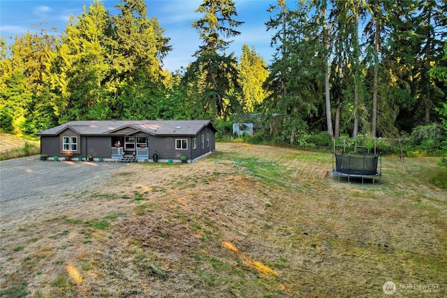 29 Sherburne Rd, Sequim, WA 98382 - view of grassy yard featuring a trampoline, covered porch, and a wooded view