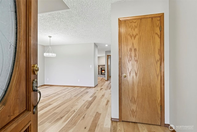 13019 NE 96th Way, Vancouver, WA 98682 - entryway featuring light wood-style flooring, a textured ceiling, and a stone fireplace