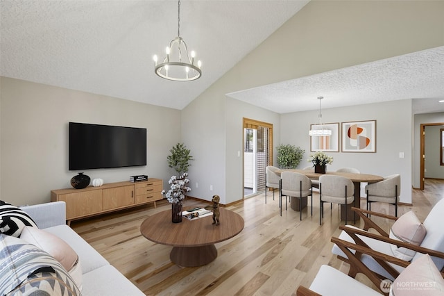 13019 NE 96th Way, Vancouver, WA 98682 - living room with a chandelier, light wood-style flooring, high vaulted ceiling, and a textured ceiling