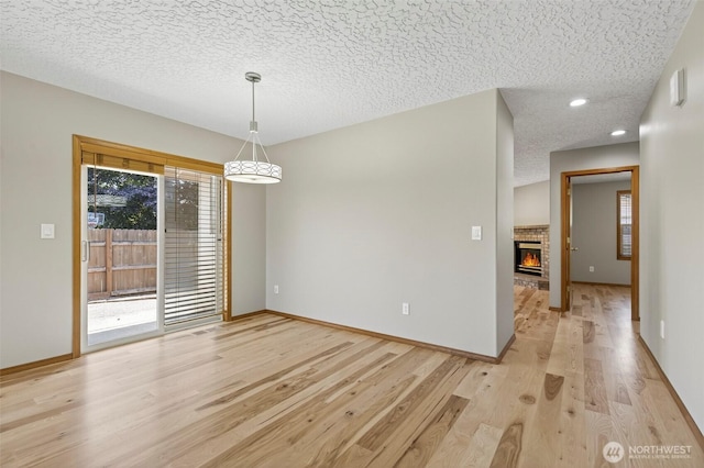 13019 NE 96th Way, Vancouver, WA 98682 - unfurnished dining area featuring healthy amount of natural light, a textured ceiling, light wood-type flooring, a glass covered fireplace, and recessed lighting