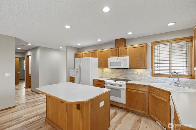 13019 NE 96th Way, Vancouver, WA 98682 - kitchen with white appliances, a kitchen island, light wood-type flooring, decorative backsplash, and light countertops