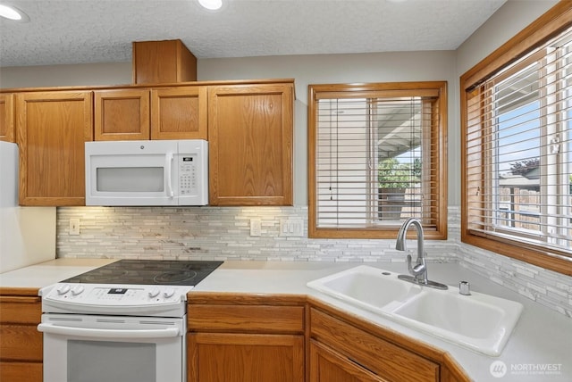 13019 NE 96th Way, Vancouver, WA 98682 - kitchen featuring white appliances, light countertops, tasteful backsplash, a textured ceiling, and brown cabinets