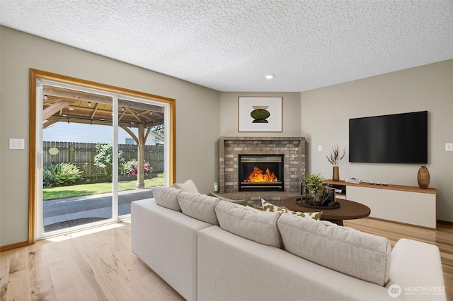 13019 NE 96th Way, Vancouver, WA 98682 - living area featuring light wood finished floors, a brick fireplace, a textured ceiling, and recessed lighting