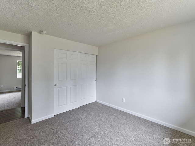 2705 181st Ave E, Lake Tapps, WA 98391 - unfurnished bedroom with dark colored carpet, baseboard heating, a closet, and a textured ceiling