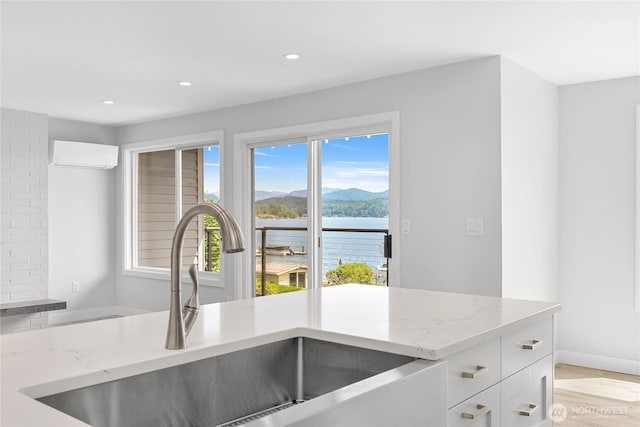 610 Northshore Dr Unit 6123, Bellingham, WA 98226 - kitchen with light stone countertops, white cabinetry, recessed lighting, a water and mountain view, and a wall mounted air conditioner